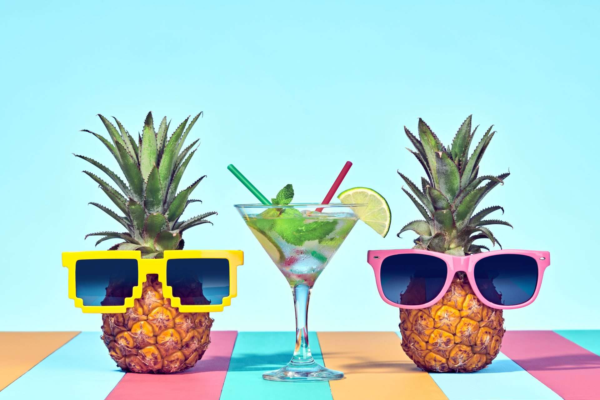Two fruits  with sunglasses on drinking cocktails