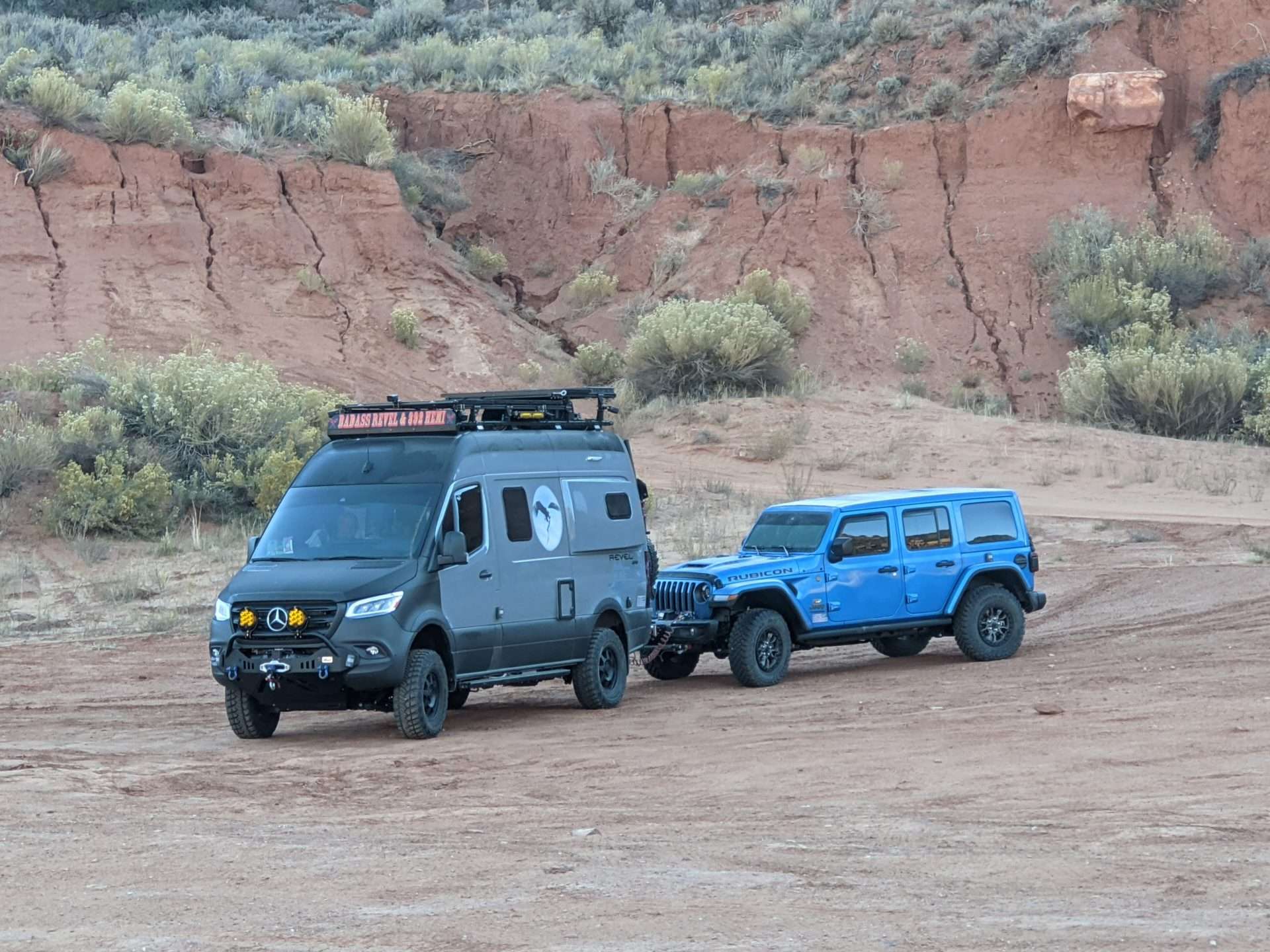 Winnebago Revel towing Jeep while off-roading