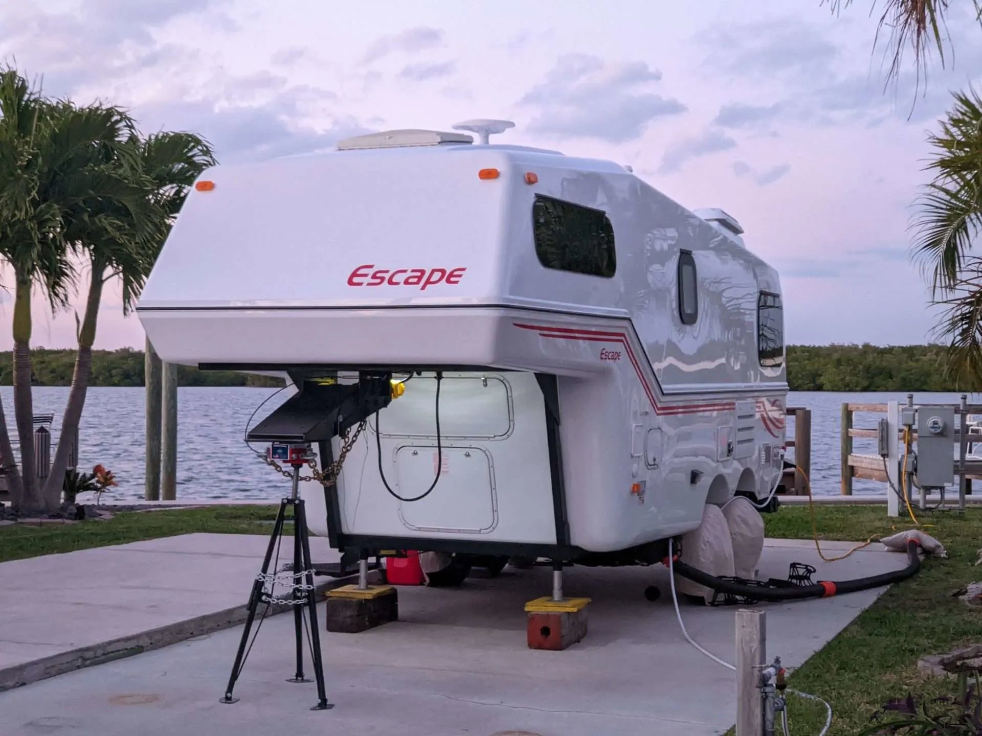 Escape fiberglass camper parked next to lake.