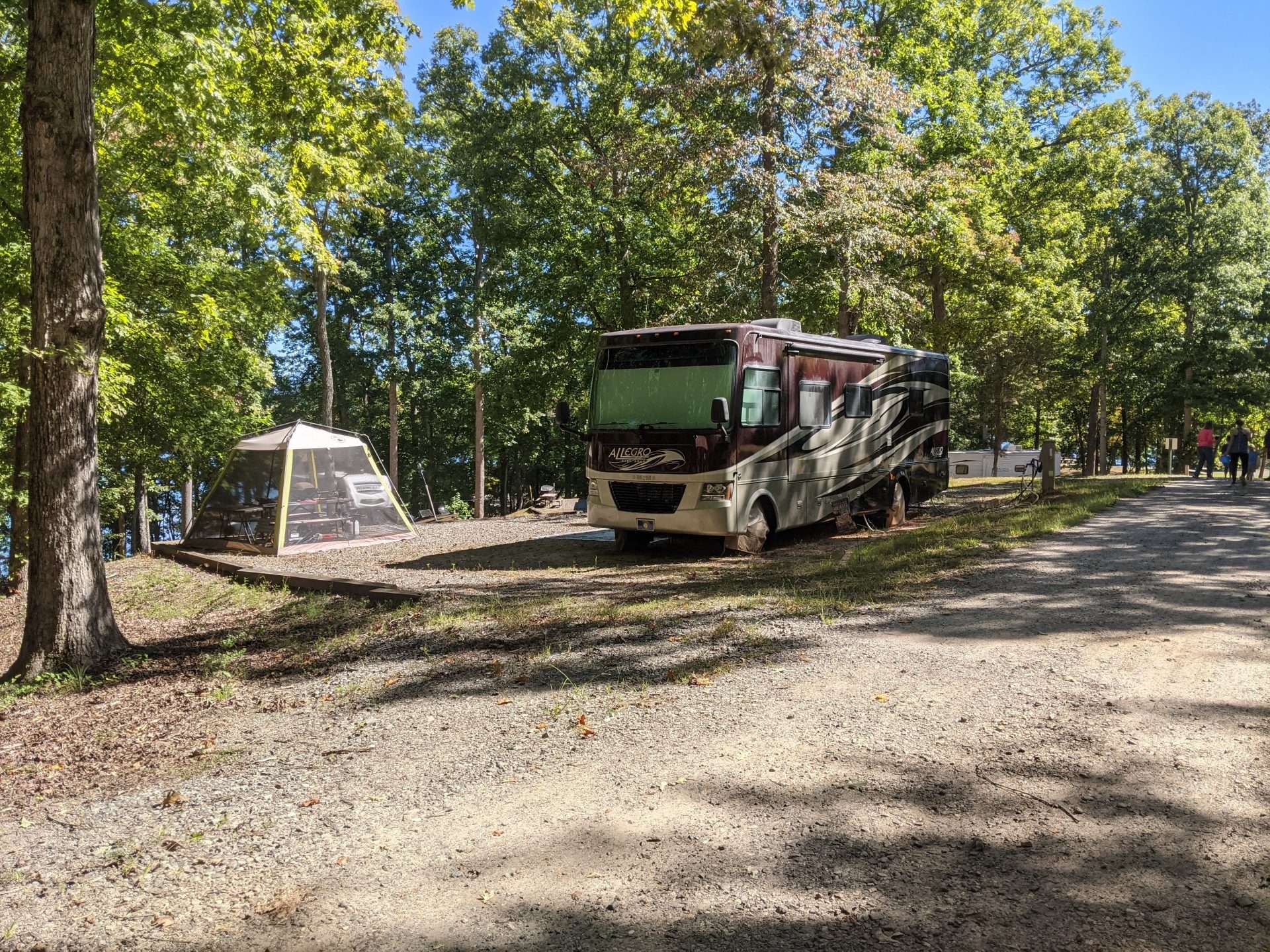 Class C RV parked at campsite in forest