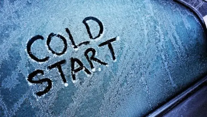 Cold start written into icy window on car