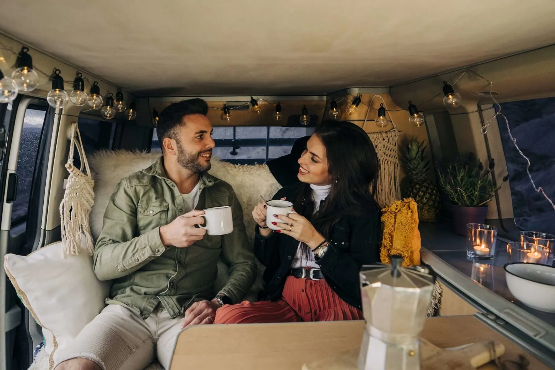 Happy young couple inside camper van