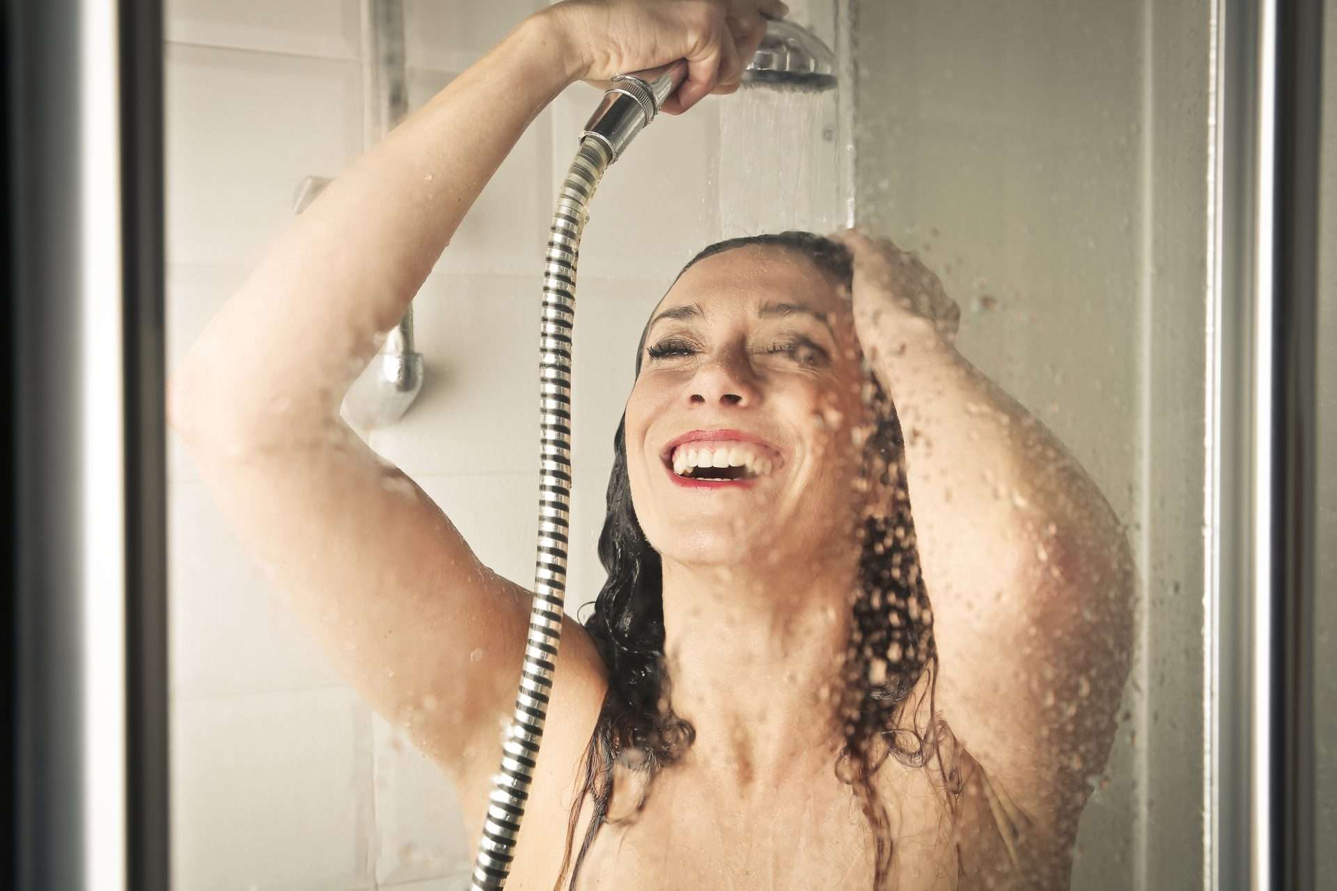 Woman happily washing hair.