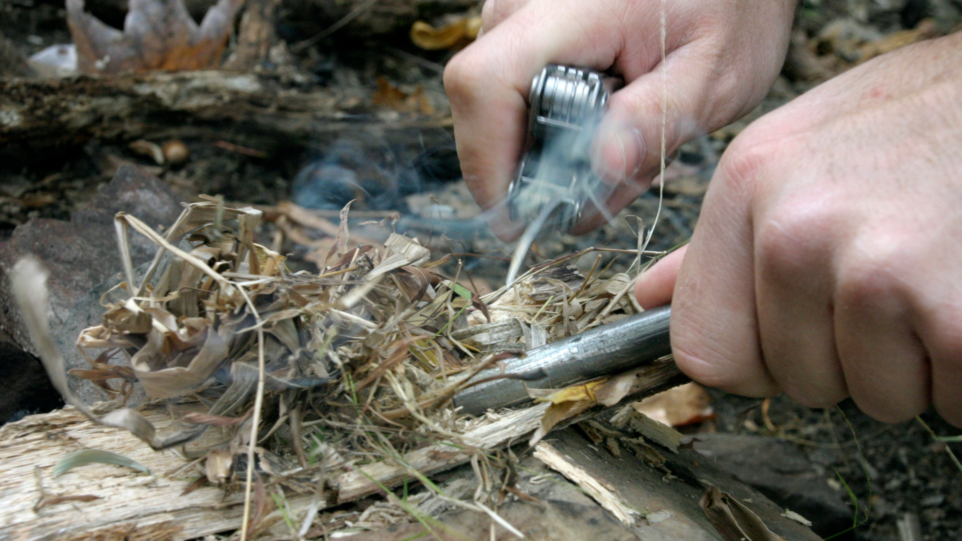 Close up of person using fire starter kit to make campfire