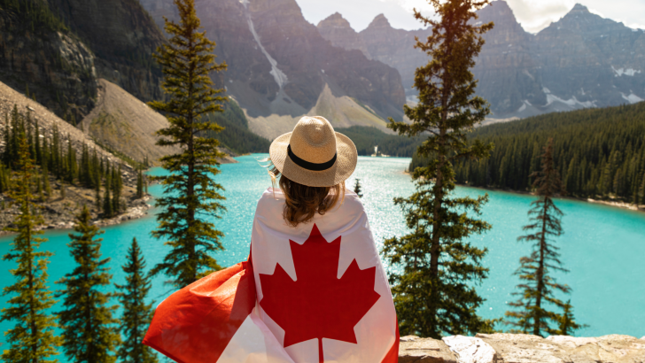 Woman hiking in Canadian National Park with Canadian flag