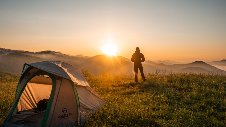 Man standing next to tent in scenic view