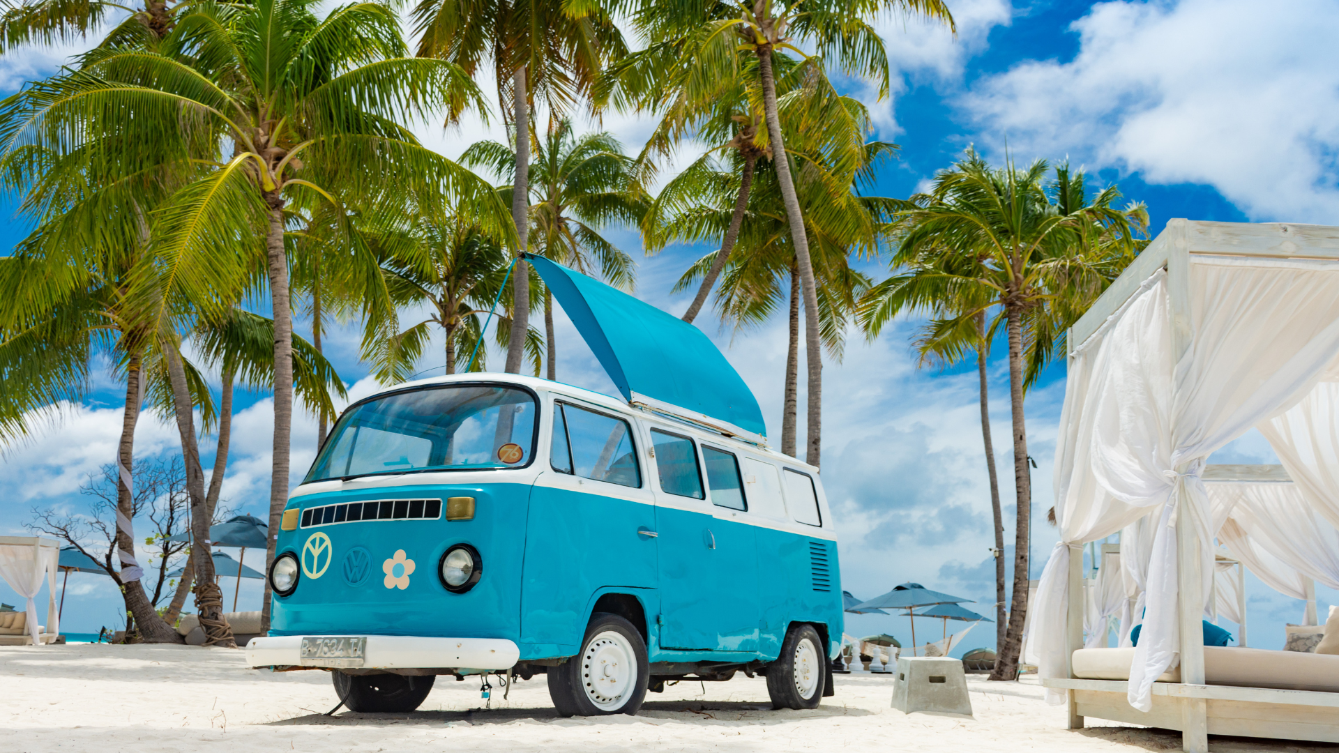 Blue Volkswagen camper van on beach