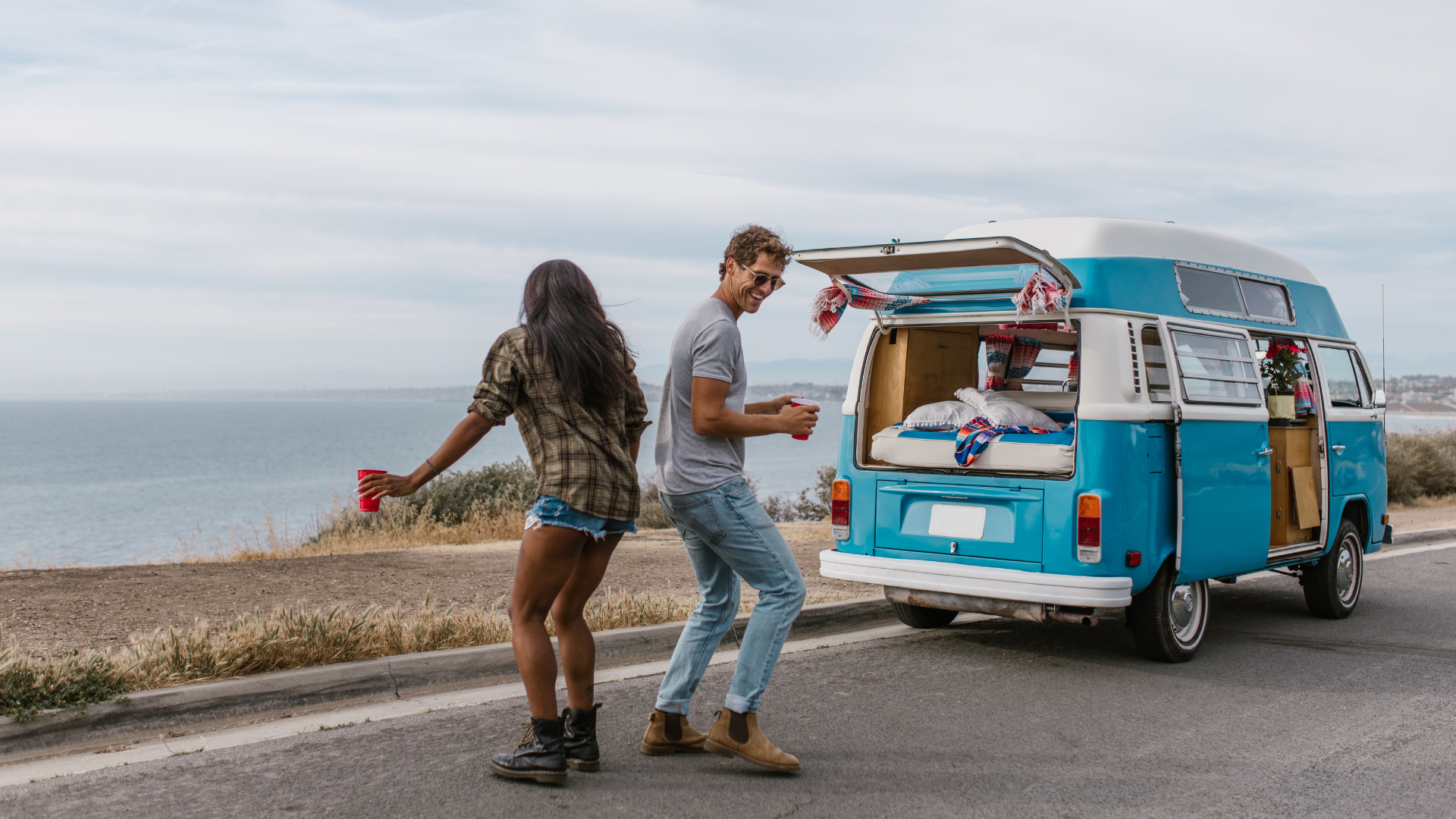 Couple dancing by Volkswagen camper van