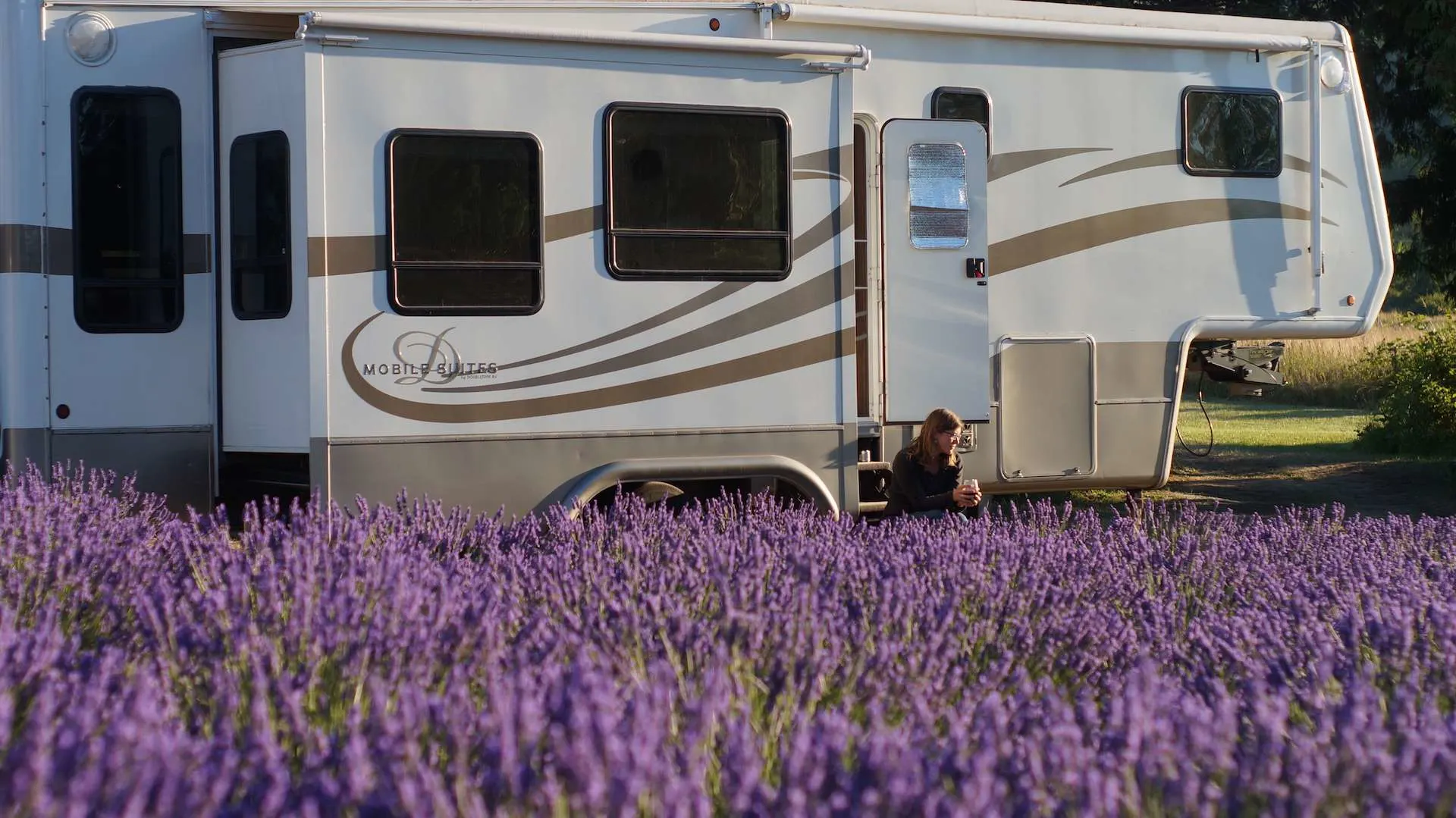 caitlin sitting on steps of drv mobile suites in lavender field