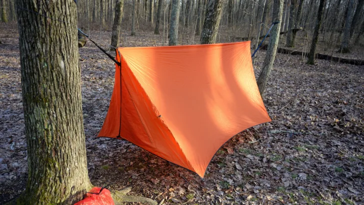 Orange tube tent set up in forest