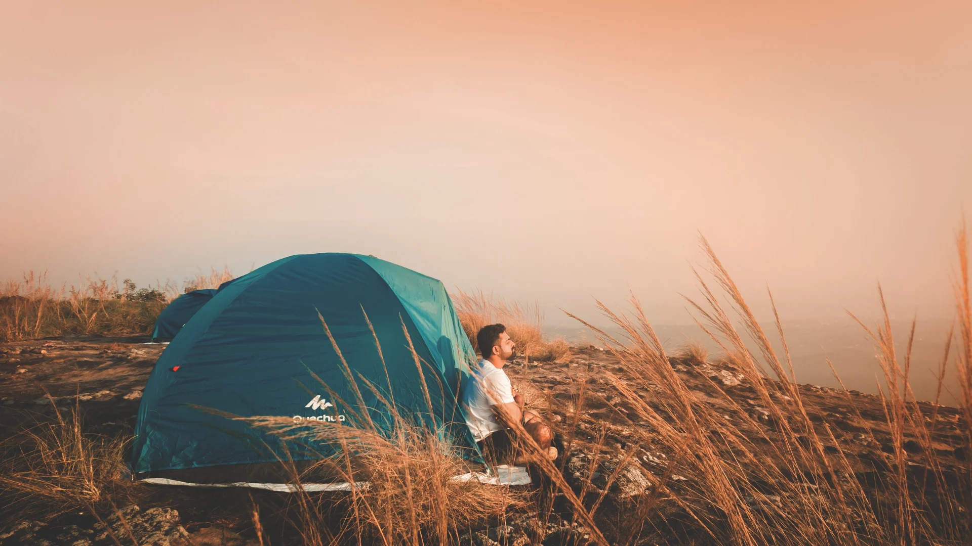 Man meditating outside of 10-person tent
