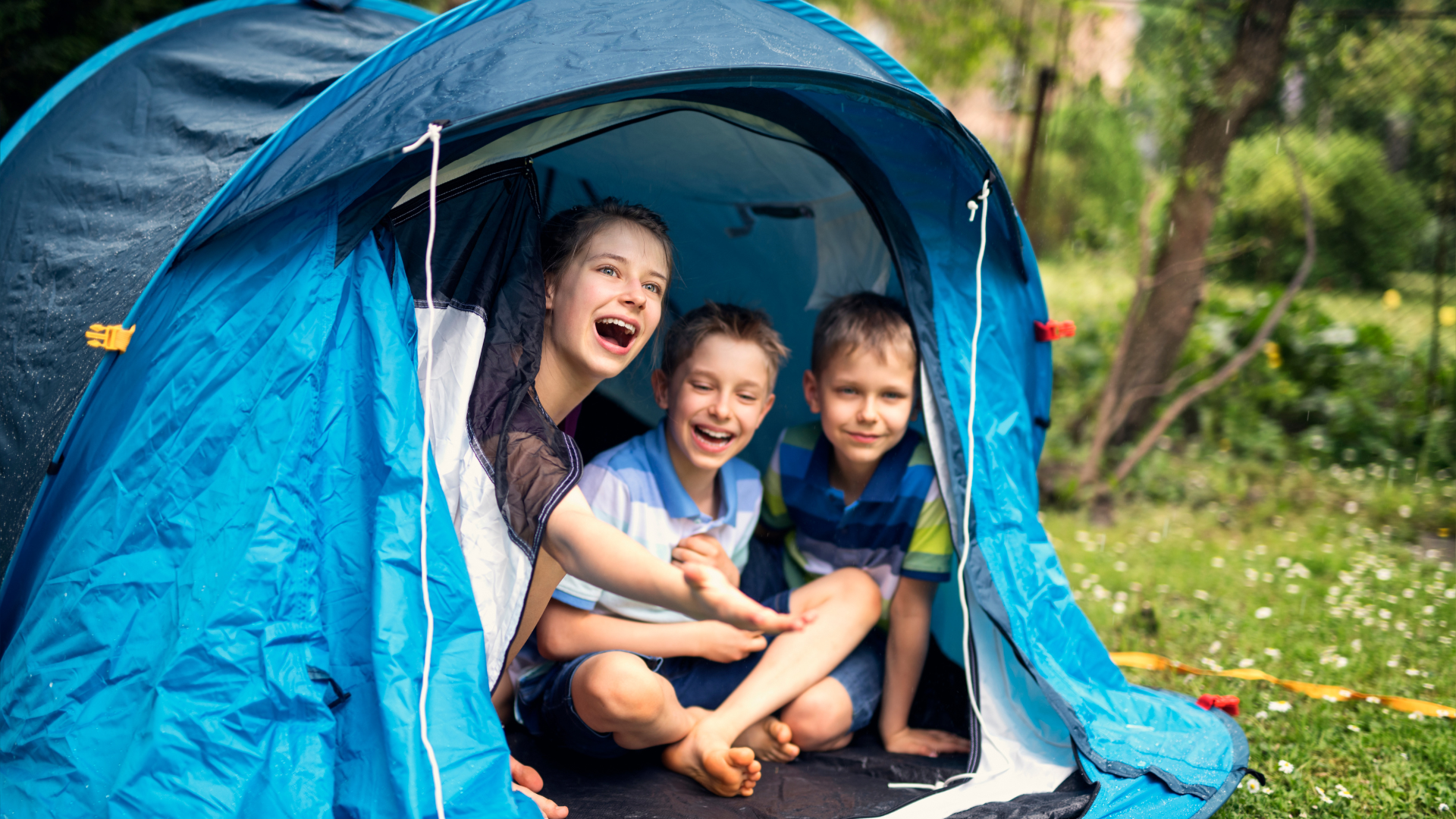Kids sitting in tent while it rains