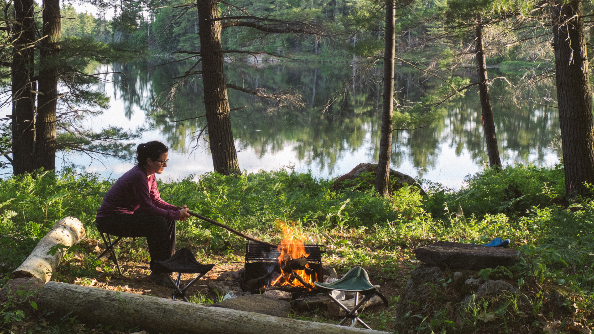 Woman cooking over campfire