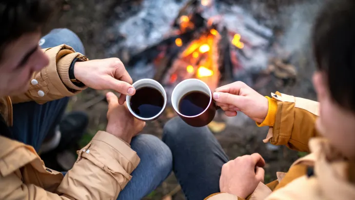 Drinking coffee by campfire