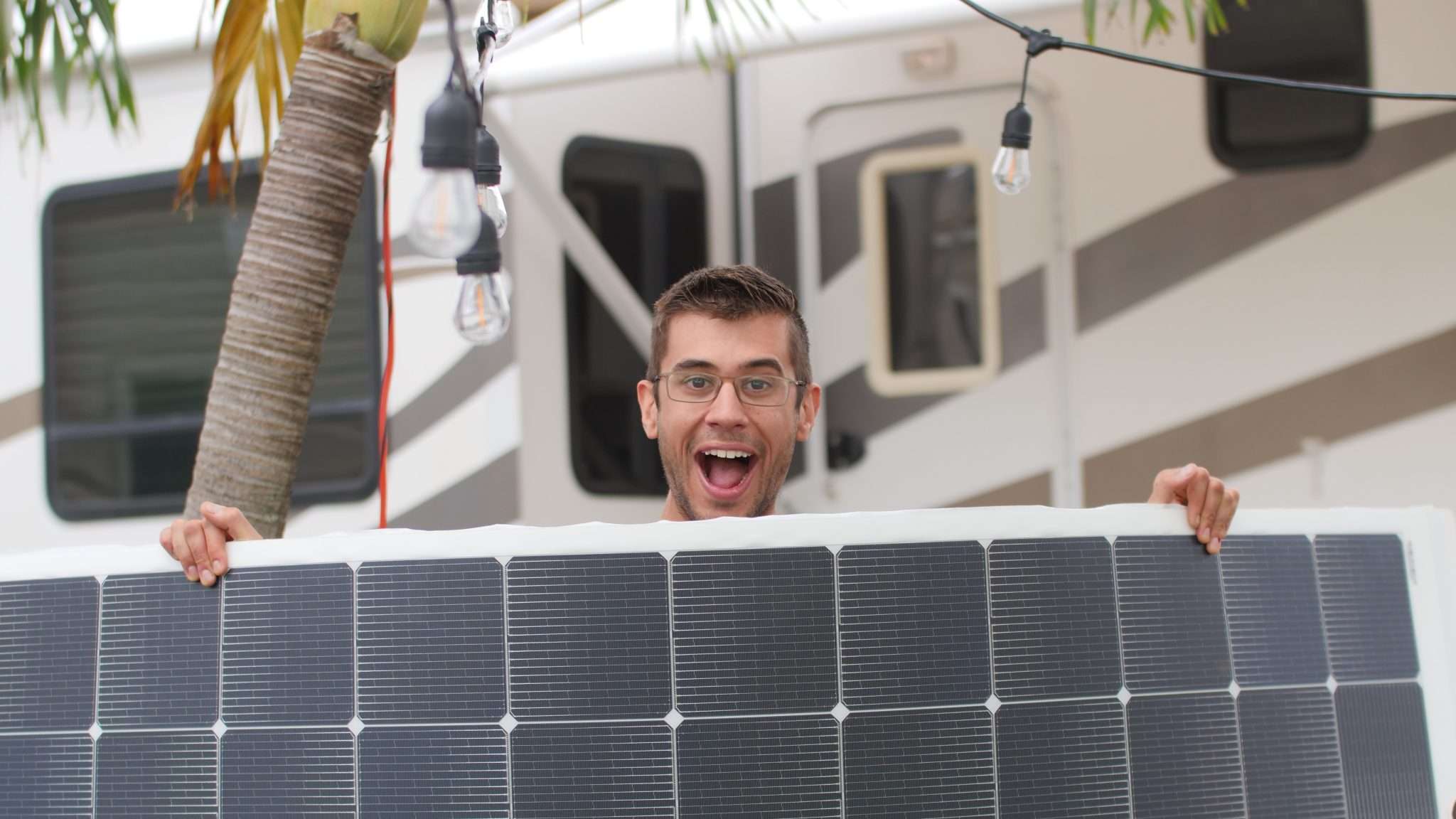 RV solar installer holding up a solar panel