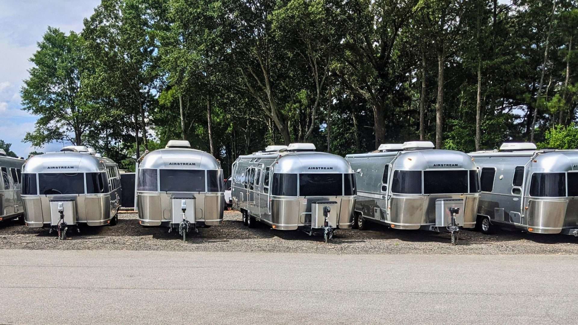 lineup of airstream campers on a dealer lot